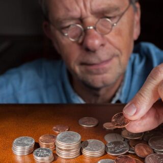Senior man counting cash into piles