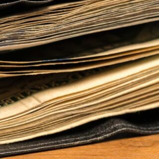 Wad of US dollar bills in black wallet on table