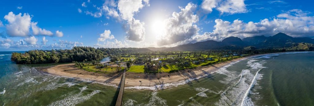 Aerial drone shot of the pier and bay at Hanalei on Kauai as the sun rises in the east