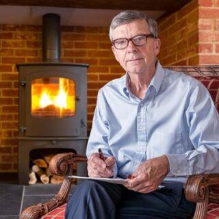 Stock photo of senior man filling in forms at home