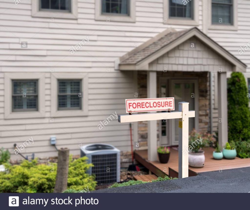 Stock photo of foreclosure sign in front of a modern townhome