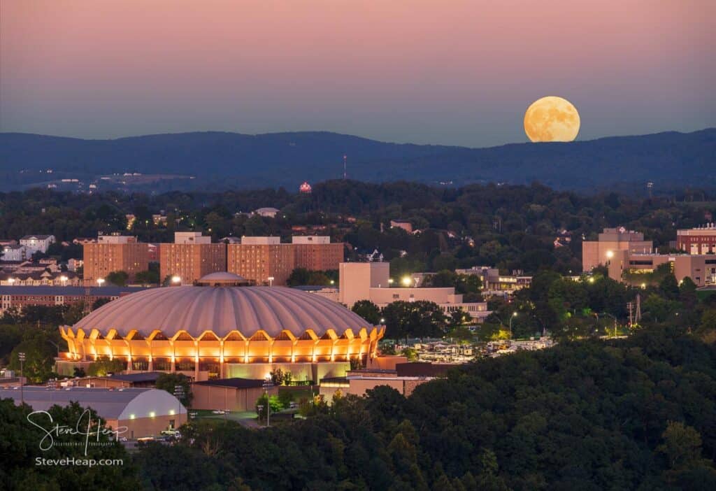 Moon rising over the hills surrounding Morgantown with the illuminated Coliseum in the foreground on the Evansdale Campus of WVU. Prints available here