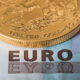 Gold coins on euro note bill with coins